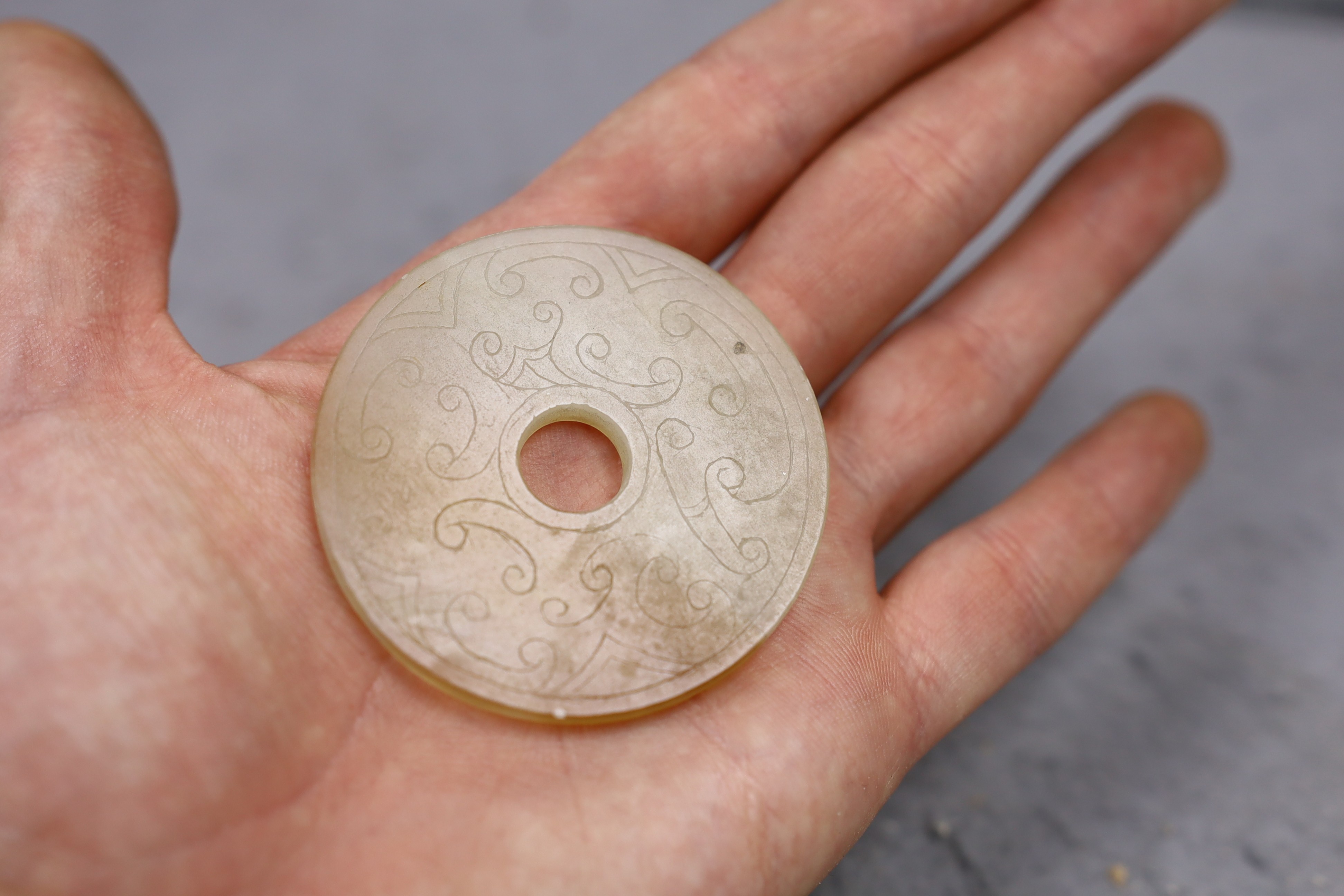 Two Chinese bi discs; in bowenite jade and black and green hardstone, largest 7cm diameter